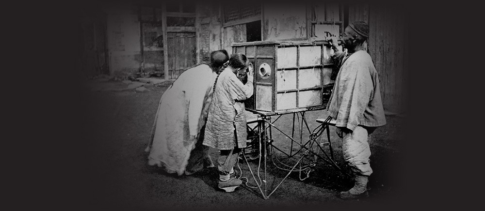 People using a peepshow in Peking in the 1800s.