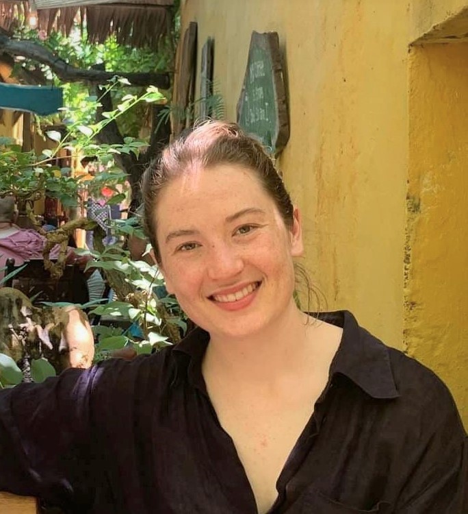 A woman wearing a black shirt smiles at the camera