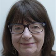 A closely cropped photograph of a woman smiling at the camera