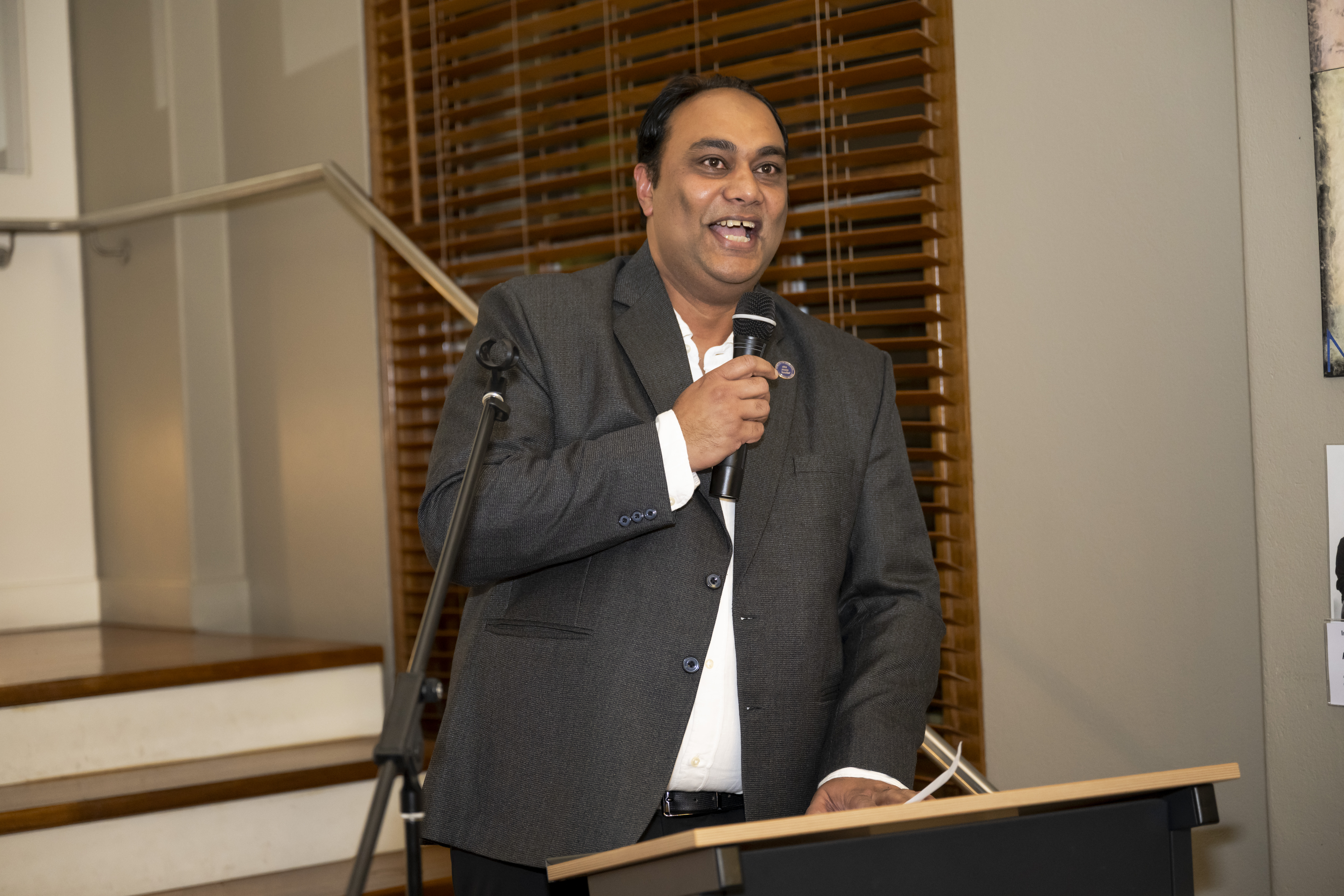 A photograph of M. Sajid Foazdar giving a speech.