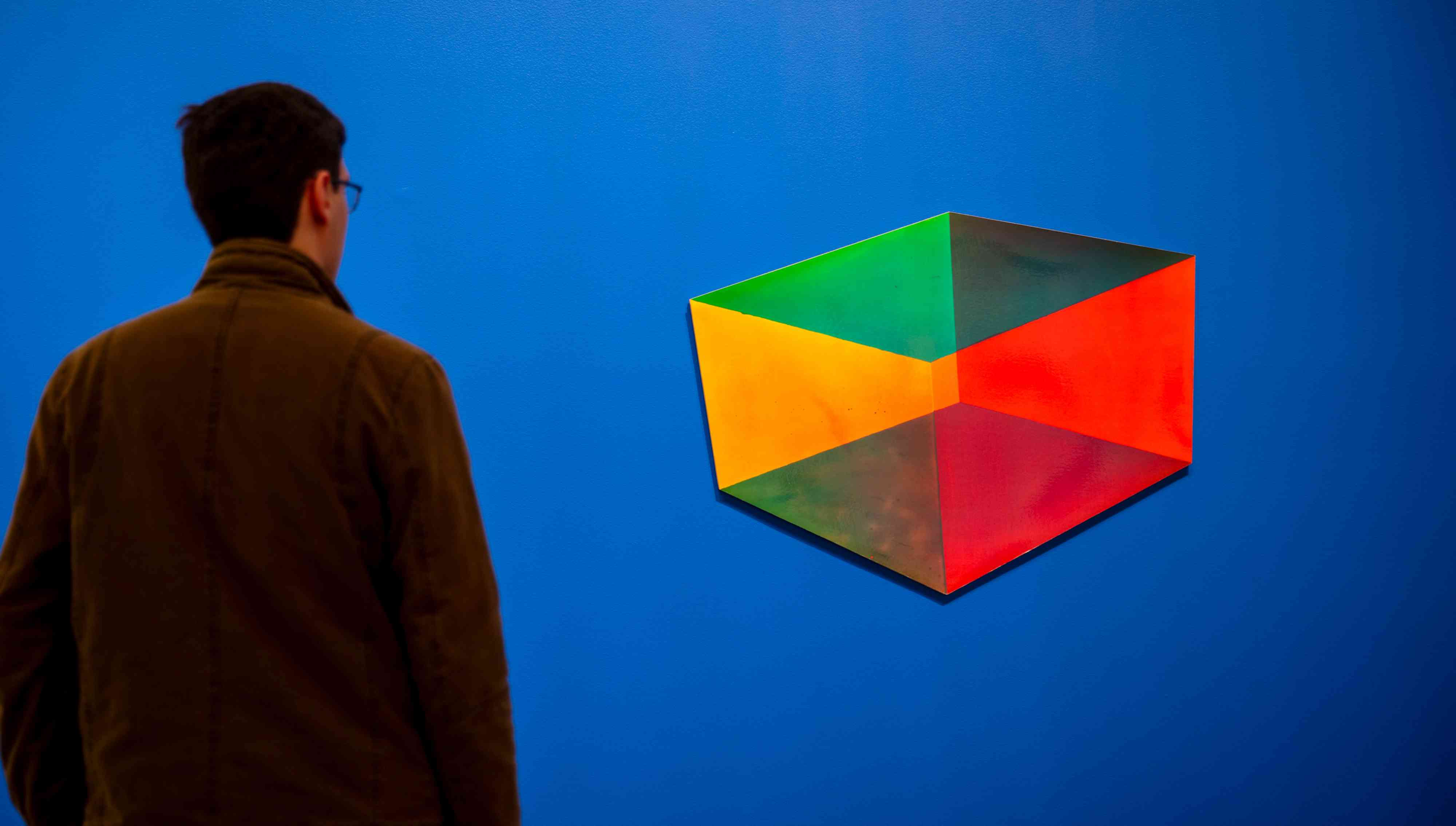A man looks at an abstract artwork