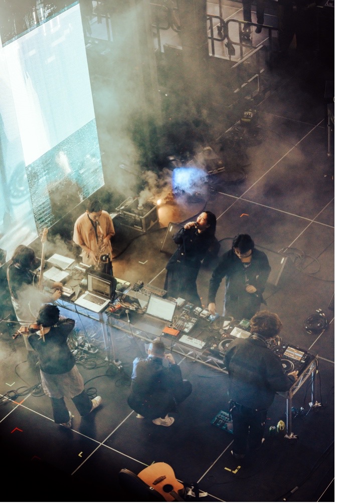 A photograph of the ensemble Worlds Only playing a smoky room.