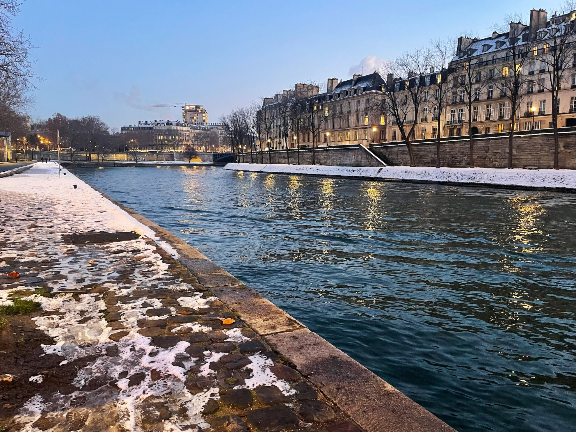 A photograph of a river with a snowy bank.